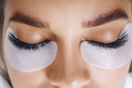 Eyelash Extension Procedure. Woman Eye with Long Blue Eyelashes. Ombre effect. Close up, selective focus.の写真素材