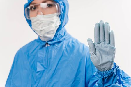 Concept of coronavirus quarantine. Concept of a global coronavirus epidemic. Treatment of coronavirus infection. Medic in hazmat protective suit show hands gesture for stop corona virus outbreakの写真素材