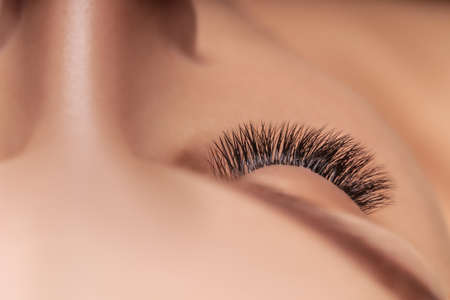 Eyelash Extension Procedure. Woman Eye with Long Eyelashes. Close up, selective focus.の写真素材
