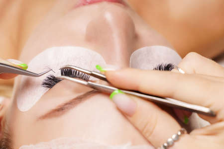 Eyelash Extension Procedure. Woman Eye with Long Eyelashes. Close up, selective focus.の写真素材