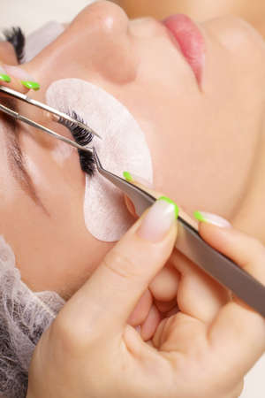Eyelash Extension Procedure. Woman Eye with Long Eyelashes. Close up, selective focus.の写真素材