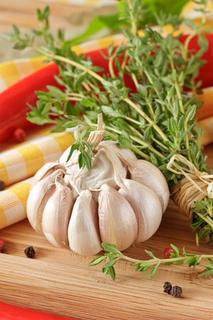 Bunch of a thyme, garlic and peppercorns on a wooden table.の写真素材