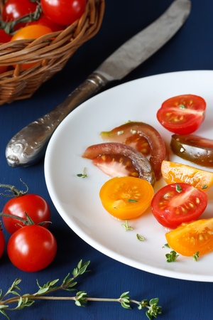 Tasty colorful tomatoes on a dark blue wooden board.の写真素材