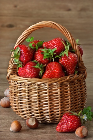 Fresh strawberries with leaves of mint on a wicker basket.の写真素材