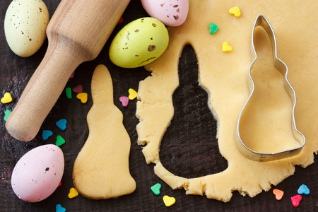 Easter bunny cookies, rolling pin and eggs on an old wooden table 