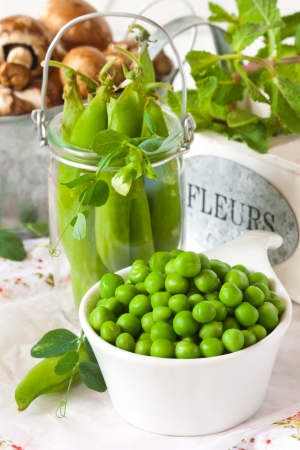 Fresh green peas with leaves in a white bowl.の写真素材