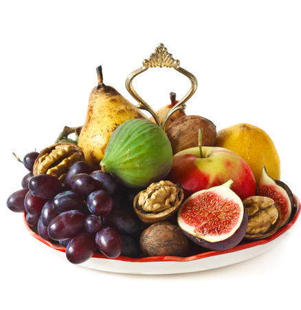 Delicious ripe fruits and nuts on a dessert plate.の写真素材