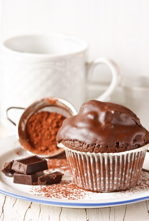 Sweet chocolate muffin on a white plate.の写真素材