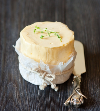 Fresh organic butter and knife on a wooden board.の写真素材