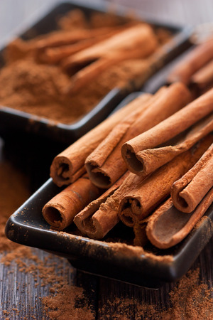 Aromatic cinnamon sticks on a black bowl.の写真素材
