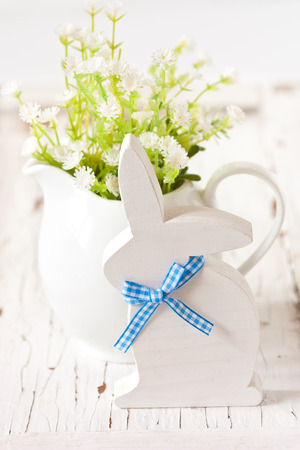 Easter decorations with white wooden bunny and spring flowers.の写真素材