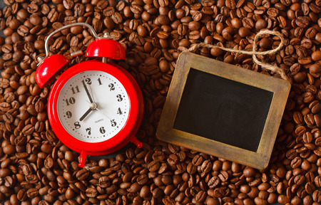 Alarm clock and chalk blackboard for text on a coffee beans.の写真素材