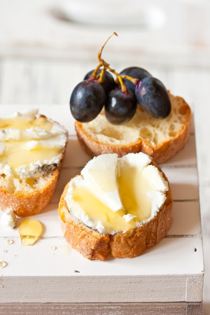 Delicious clue cheese crostini appetizer with honey and agrape.の写真素材