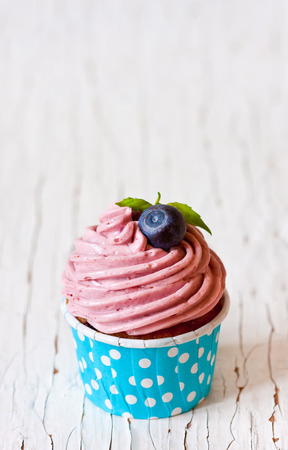 Delicious blueberry cupcake on an old wooden board.の写真素材