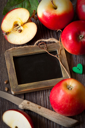 Red ripe apples and chalk blackboard for text on a wooden board.の写真素材