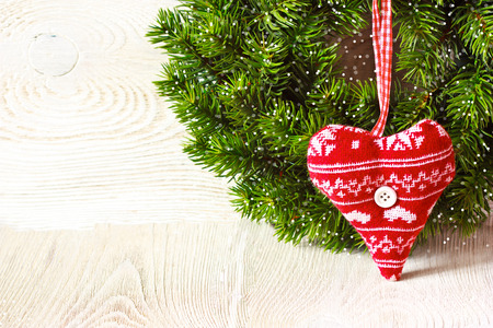 Christmas wreath with handcrafted  heart hanging on rustic white background with space for text.の写真素材