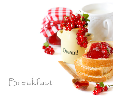 Fresh bread, sweet homemade red currant jam and mug of milk for breakfast.の写真素材