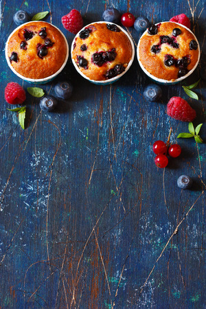 Sweet muffins and fresh berries background for text or recipe.の写真素材