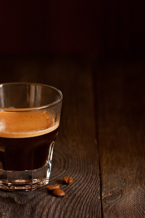 Morning cup of coffee with coffee beans on a brown background with copy space for text.の写真素材