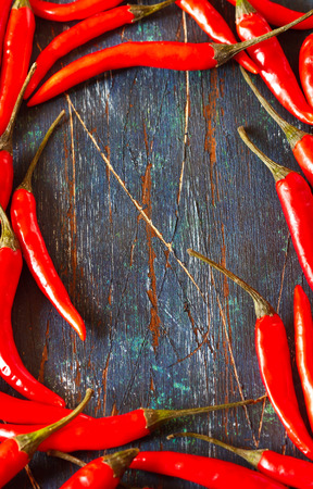 Red hot chili frame on an old wooden board with copy space.の写真素材
