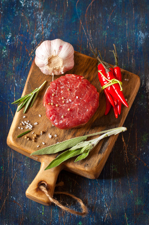 Fresh raw meat, spices and vegetables on an old blue background.の写真素材