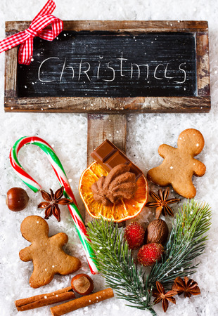 Christmas decoration with chalk blackboard invitation and Christmas sweets on snow.の写真素材