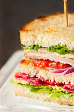 Big sandwich with ham, sausage end cheese closeup.の写真素材