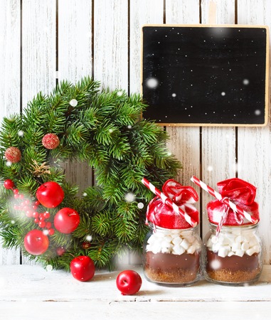 Chocolate mix with marshmallow in glass for gift or cooking holiday drink and Christmas decorated wreath.の写真素材