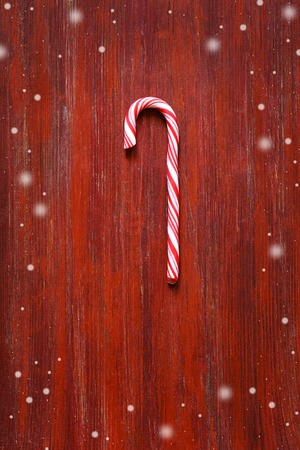 Christmas candy cane on old red wooden boardの写真素材