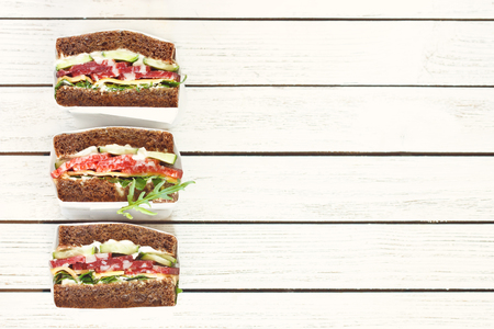 Wrapped delicious salami sandwiches on white background.の写真素材