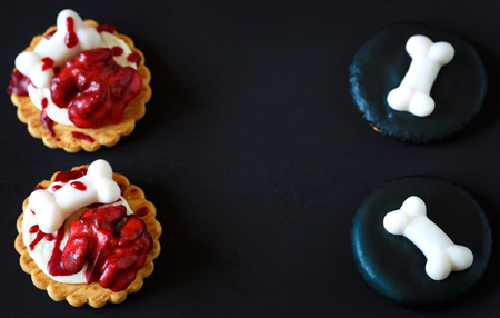 Fresh halloween bloody brain and sugar bones biscuits on dark background with place for text.の写真素材