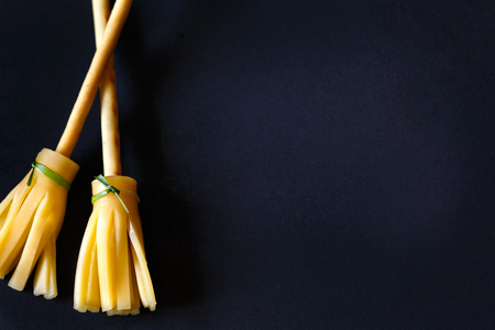 Halloween pretzel stick cheese brooms with place for text on black.の写真素材