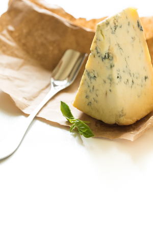 Slice of blue Stilton cheese and stilton spoon on a white background.の写真素材