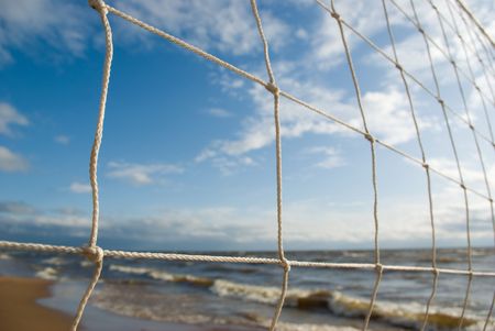 Sea coastline landscape through volleyball netの写真素材