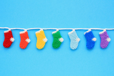 Christmas stockings hanging on blue background. Colorful rainbow socks. Odd socks day mismatch...