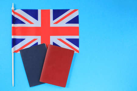 Passports and flag of Great Britain on blue background. Immigration, refugee, change of citizenship, refuge, residence, brexit European Union concept. Travel, recieving visa ideaの写真素材