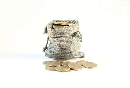 Coins fall out of a burlap sack canvas bag on white background. Accumulation money and investment savings concept. Numismatics. Old collectible coins. Flatly, flatlay, flat lay,の写真素材