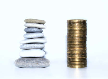 Tower pyramids from coins and pebbles on grey background. Stability, growth, wealth, financial...