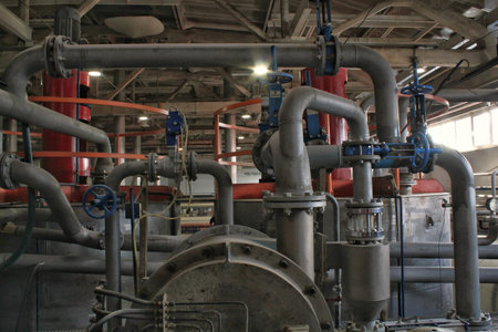 Steel pipes, tubes, steam turbine, valves, machinery, cables of modern factory. Gas boiler room of industrial zone power plant. pump engineering station. technical equipment systemの写真素材