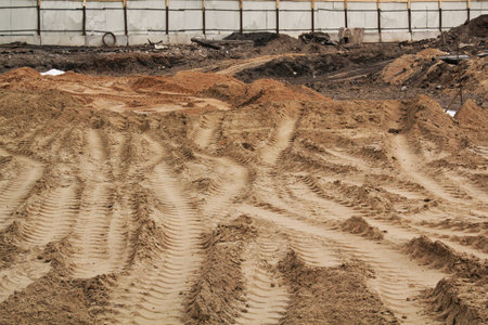 Tire track mark lines shape on dry sand background. Trail tire imprint from heavy machinery. vehicle shape. Road construction site backdrop concept. Trace of wheel pattern on mud. nature texture.の写真素材