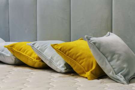 Close-up of comfortable colorful soft pillows on bed. Stylish trendy apartment home decor. Hygge scandinavian loft design. Interior of modern bedroom in hotel. Comfort sleep and reの写真素材