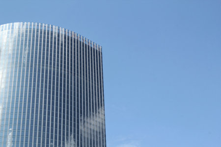 Low angle view of modern skyscraper in Hong Kong. Office building in city on blue sky background....