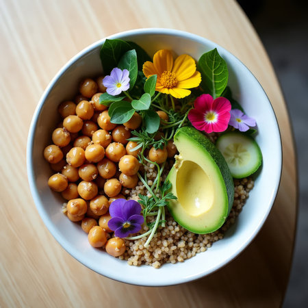 Floral Buddha Bowl. Vibrant vegetarian bowl featuring chickpeas, avocado, quinoa and edible flowers, garnished with fresh herbs in a white ceramic bowl.の素材