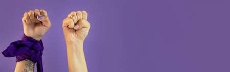 Womans hand with signs on purple background with paleacate or bandana of womens day. High quality photoの写真素材