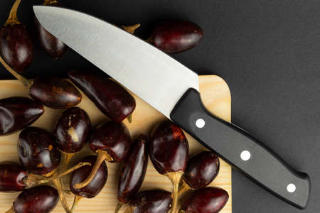 Knife with wooden board and chilies. High quality photo