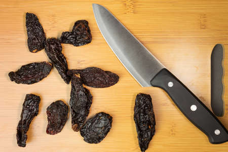 Knife with wooden board and chili peppers. High quality photo