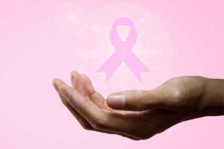 Womans hand holding a pink ribbon for October 19, World Day to Fight Breast Cancer. High quality photoの写真素材