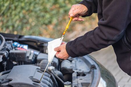 Man is checking oil level on carの写真素材