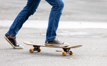 person is riding on the skateboard in autumnの写真素材