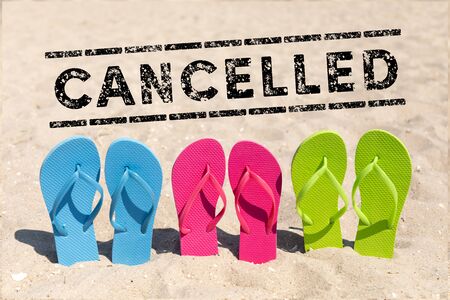 flip flops in the sand and text cancelled - holiday cancelの写真素材